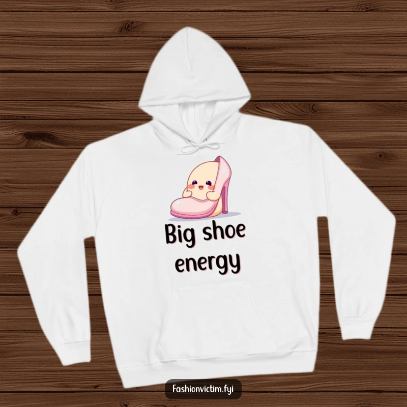 Funny hoodie showing a cheerful blob character admiring an oversized, sparkly shoe, offering warmth and a touch of glamorous humor.